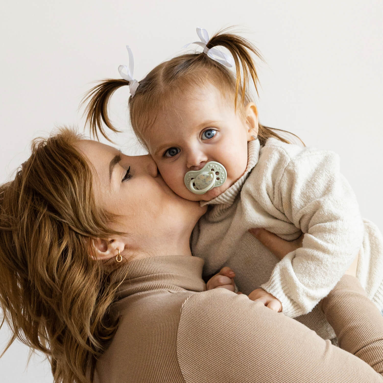 Sucette dynamique Blossom Difrax LOVI portée par un enfant avec sa maman
