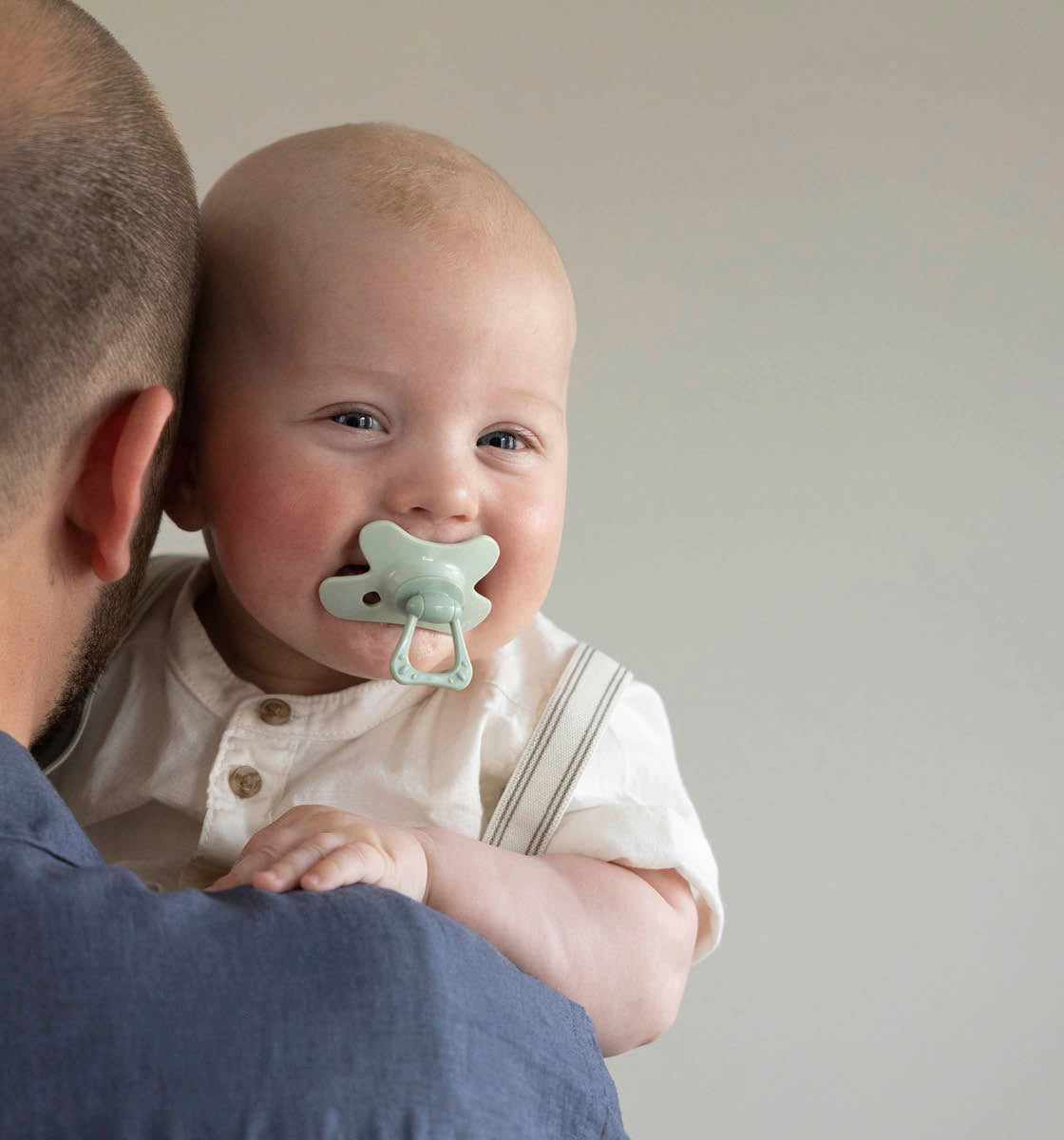 Baby lachend met fopspeen