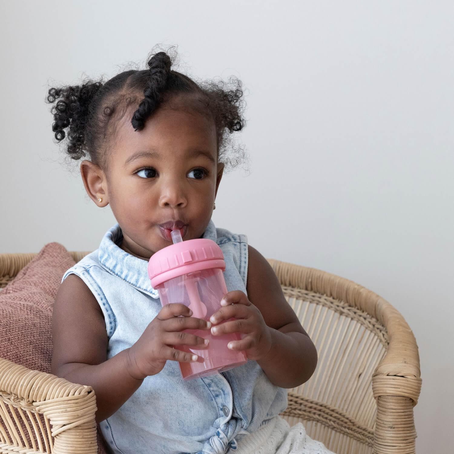 Meisje drinkt uit roze difrax antilek rietjesbeker