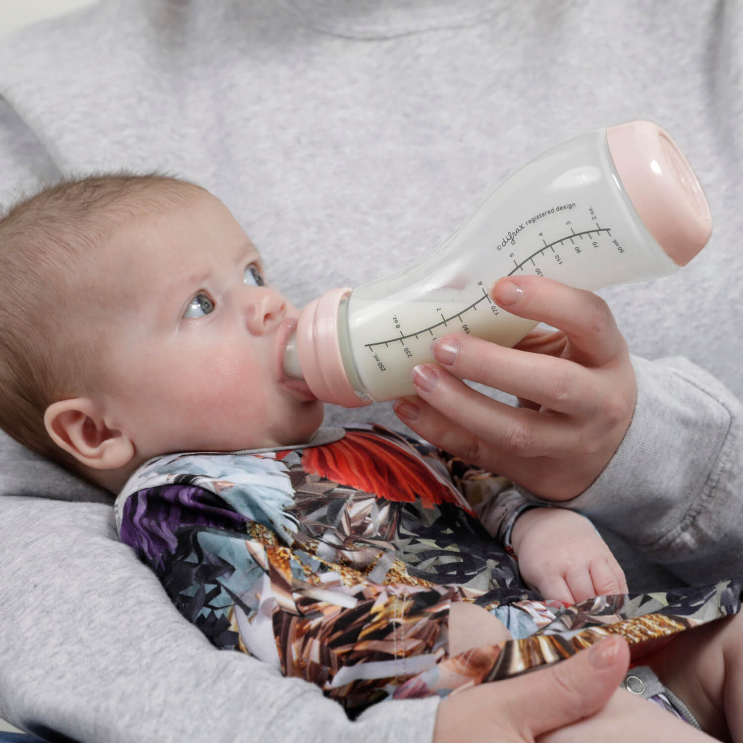 Baby wordt gevoed met Difrax S-fles glas 250ml Blossom - de unieke S-vorm volgt de natuurlijke drinkbeweging voor ontspannen voedingsmomenten