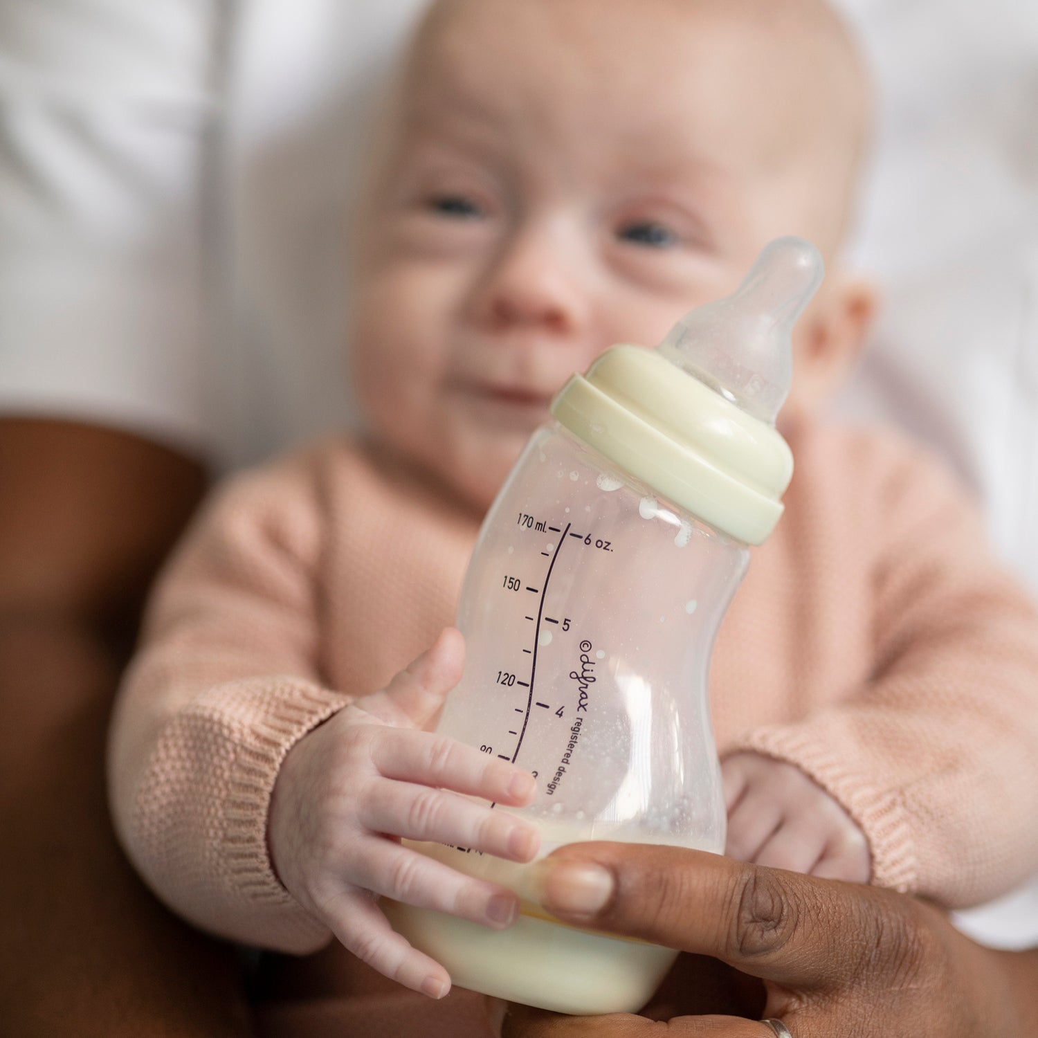 Pasgeboren baby krijgt flesvoeding samen met kraamzorg