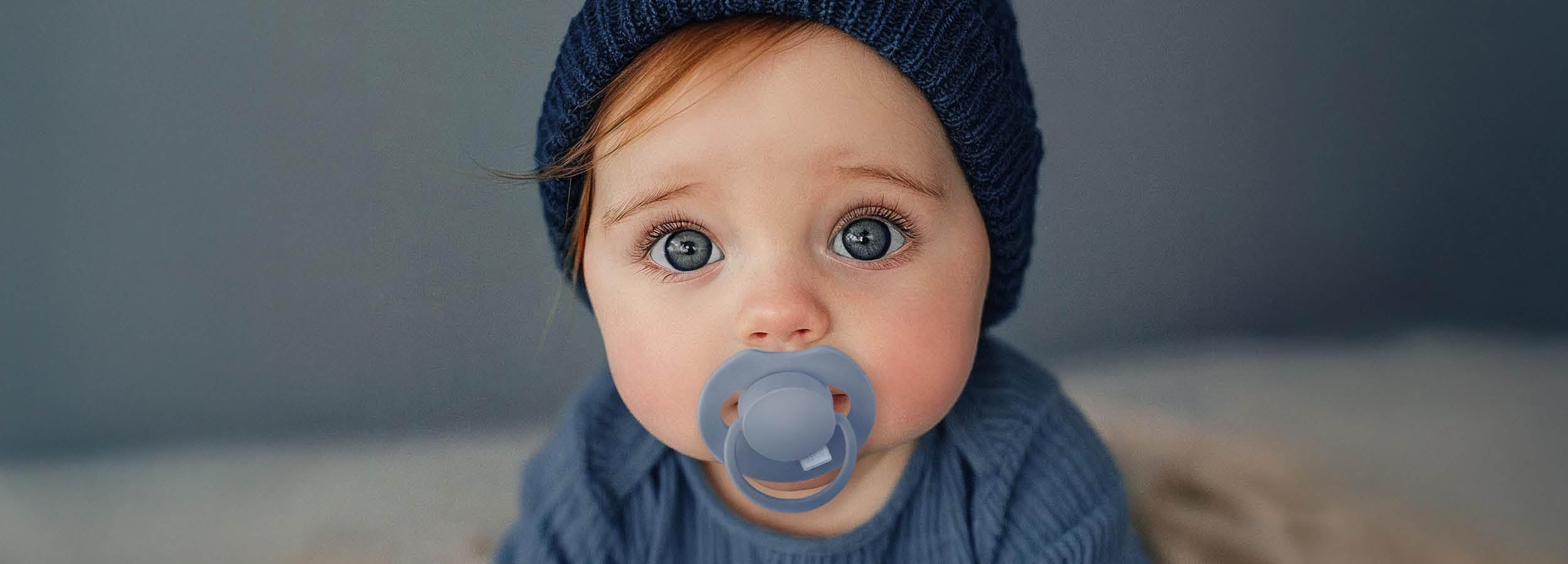 Kindje met blauwe Prime fopspeen