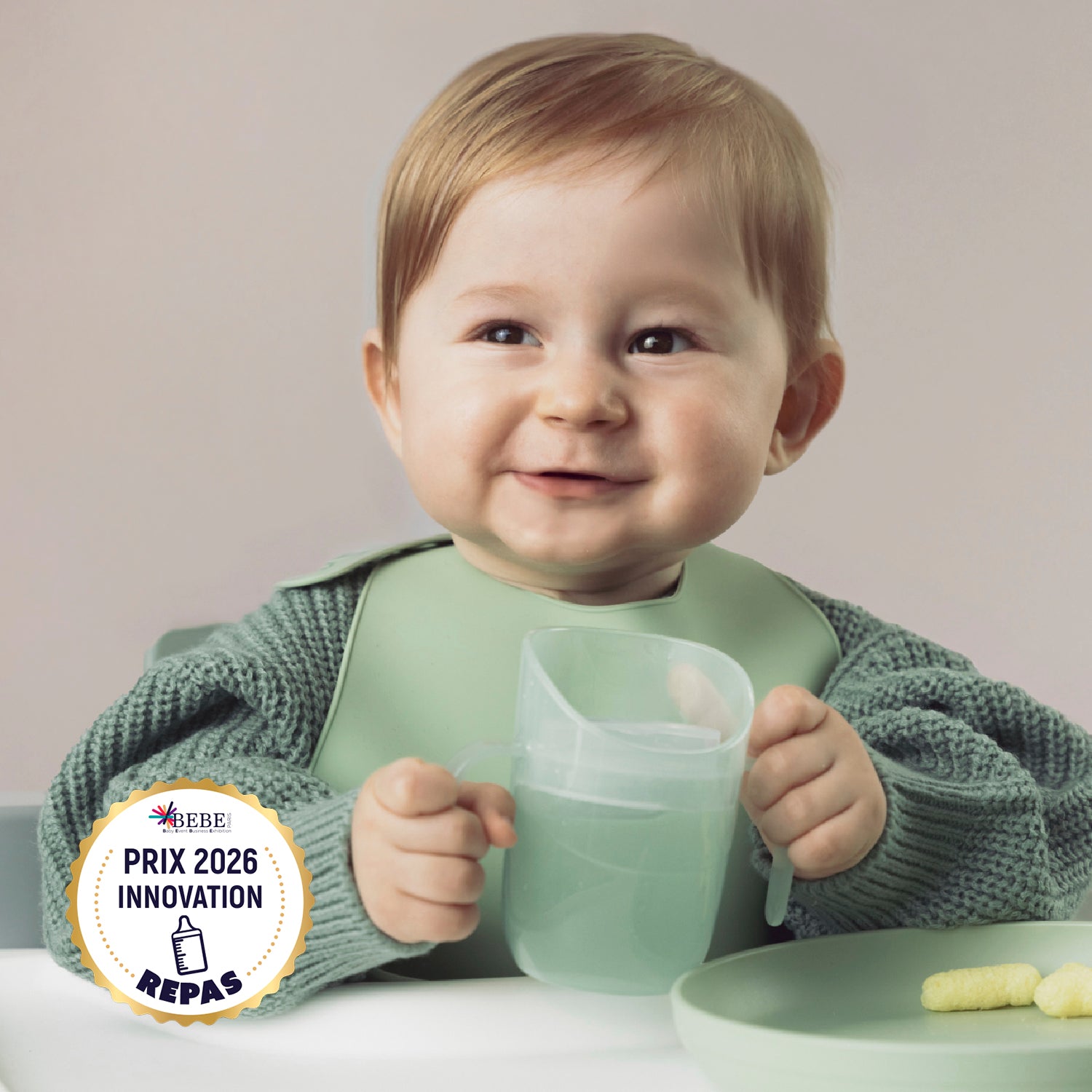 Kindje houdt glimlachend de Difrax LOVI Genius Cup vast in de kleur Pistachio, winnaar van de Prix 2026 Innovation Award, ontworpen voor kinderen vanaf 6 maanden om zelfstandig te leren drinken met een natuurlijke, veilige drinkhouding.