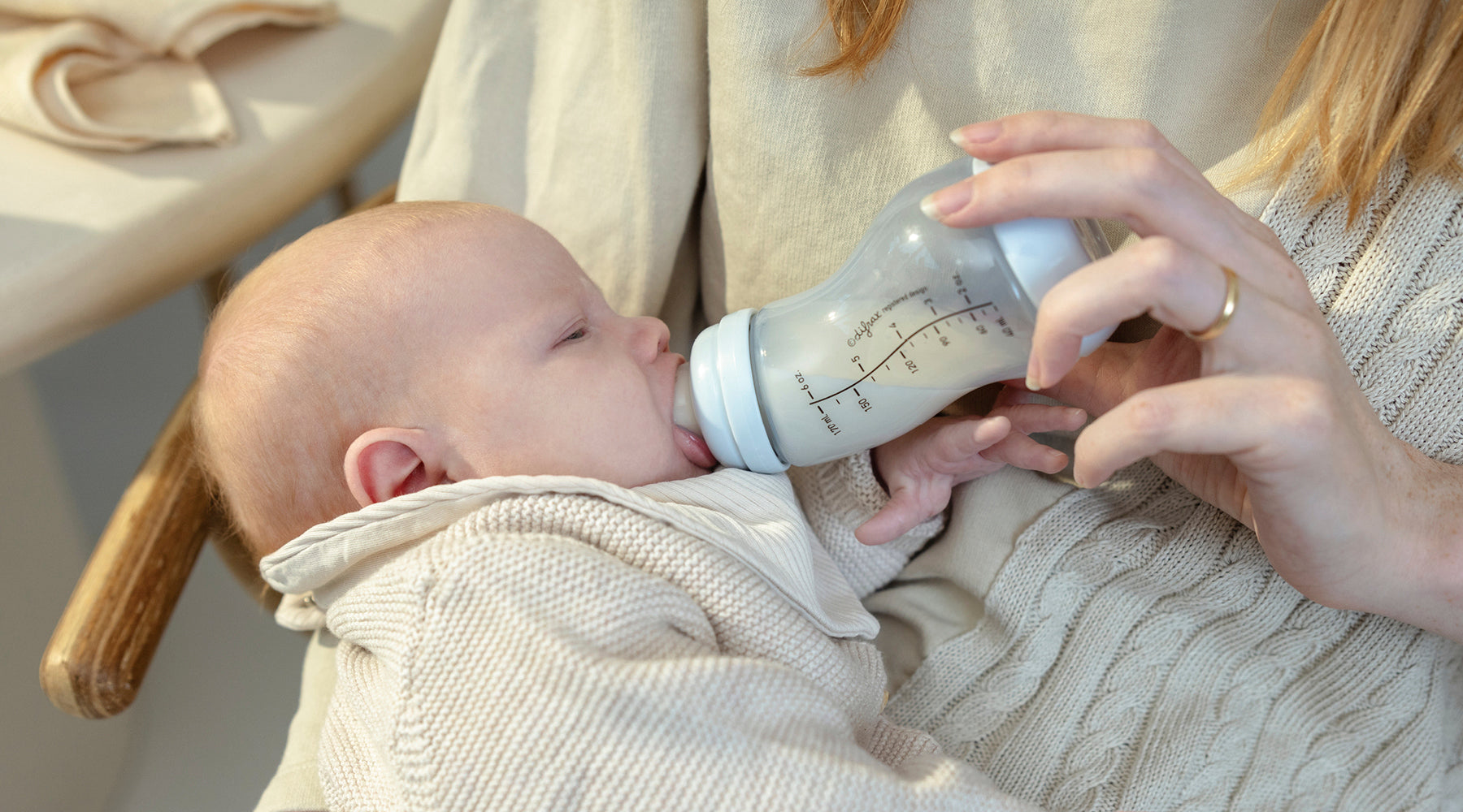 Baby drinkt uit Difrax anti-colic S-fles in armen van moeder