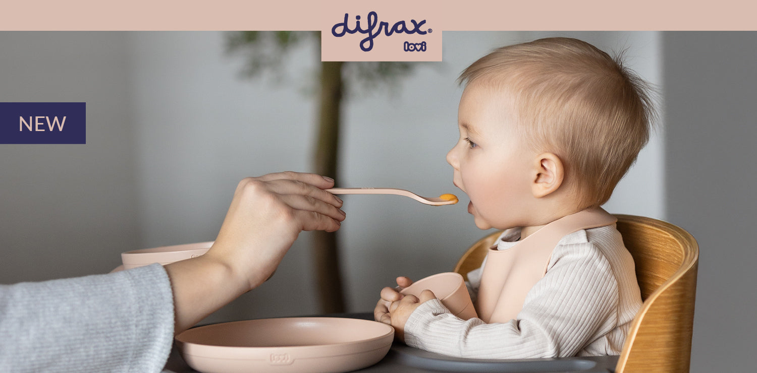 Baby in a high chair being fed with the Difrax LOVI Tableware set with cup in nude color