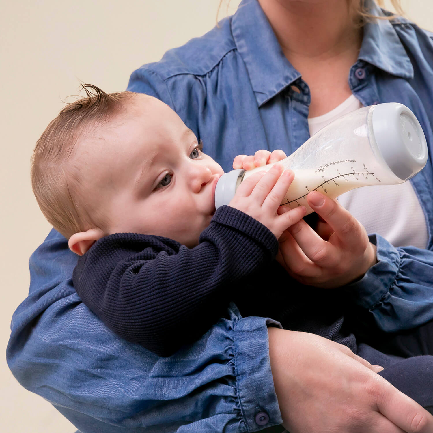 Baby wordt gevoed met Difrax S-fles glas 250ml Blossom - de unieke S-vorm volgt de natuurlijke drinkbeweging voor ontspannen voedingsmomenten