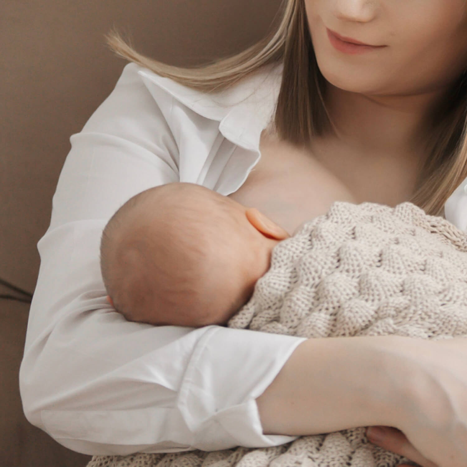 Moeder die haar baby borstvoeding geeft, met gebruik van zoogkompressen voor extra comfort

